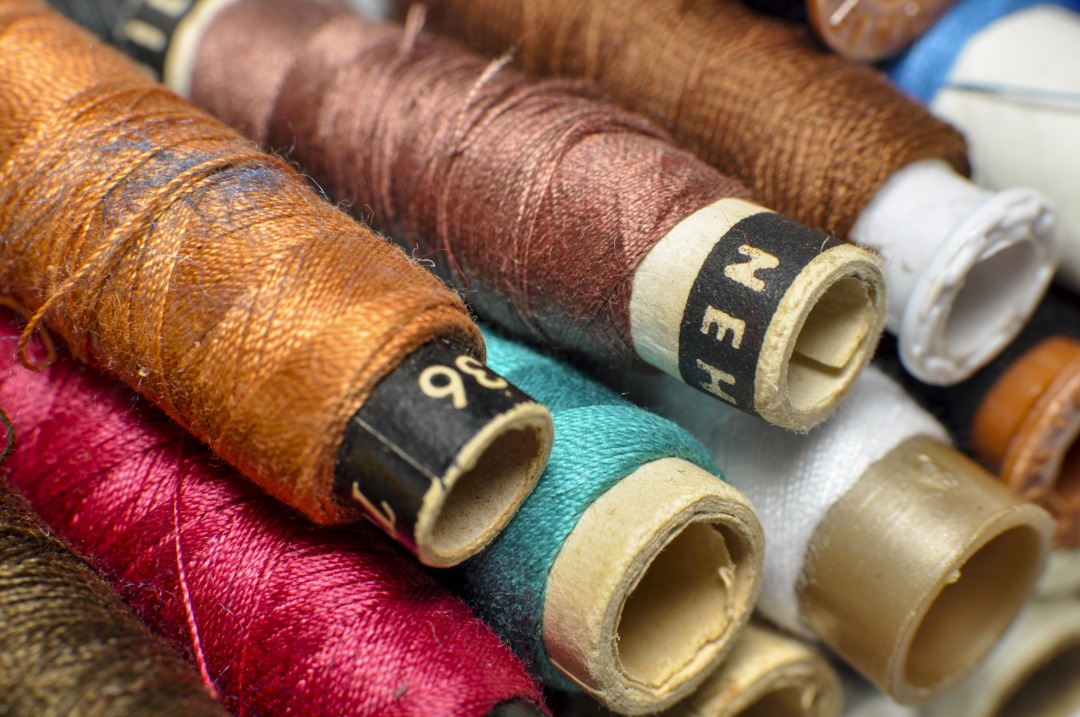Sewing threads multicolored background closeup