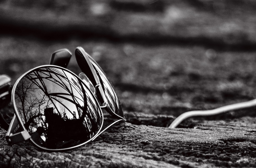 a pair of sunglasses sitting on top of a rock