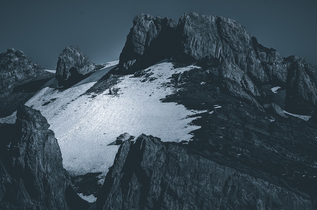 a mountain with snow on it and a moon in the sky