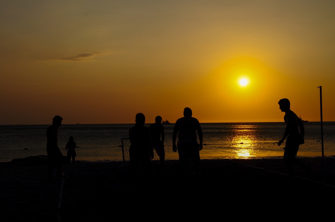 Amateurs playing football at Jumeira beach in Santa Marta, Colombia during sunset.