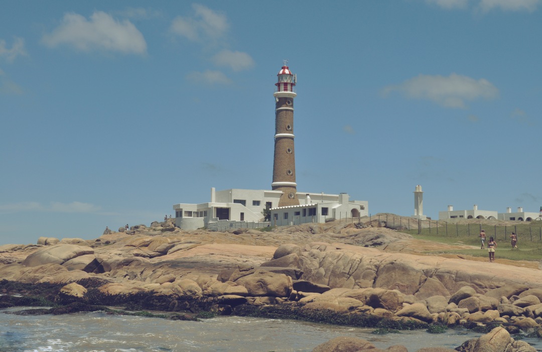 a lighthouse on the rocks near the ocean