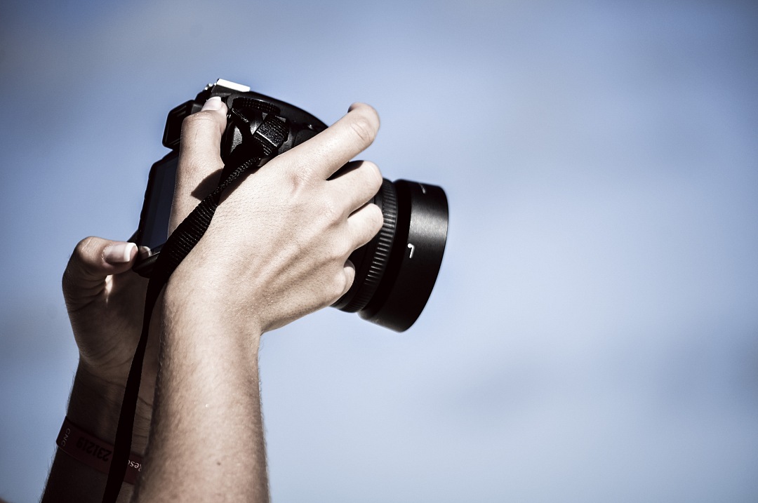 a man holding a camera up to the sky