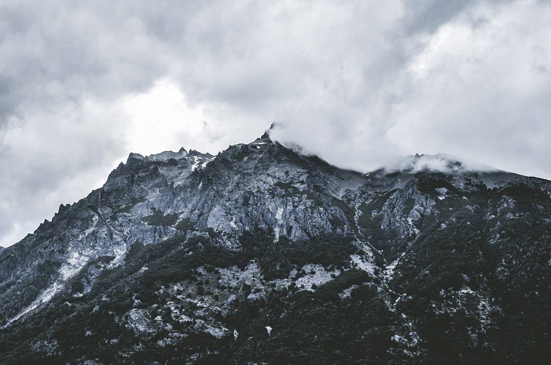 a mountain with a cloudy sky above it