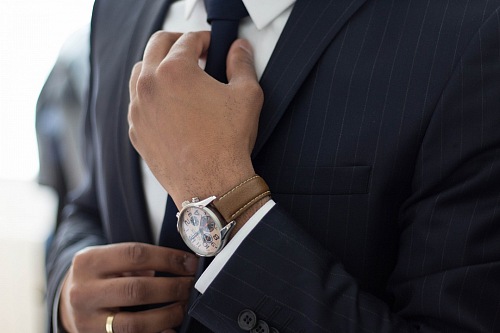 businessman with suit adjusting his tie