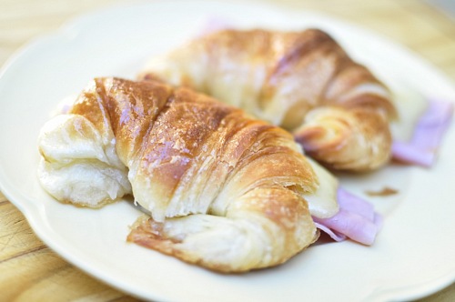Fresh croissants with ham and cheese on plate Medialunas
