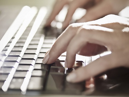 business woman typing on a laptop keyboard